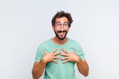 Genç sakallı adam mutlu, şaşırmış, gururlu ve heyecanlı görünüyor.