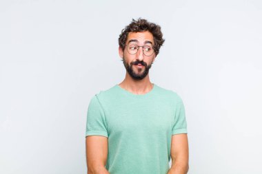 Genç sakallı adam merak ediyor, mutlu düşünceler ve fikirler düşünüyor, hayal kuruyor, kenarda yer arıyor.