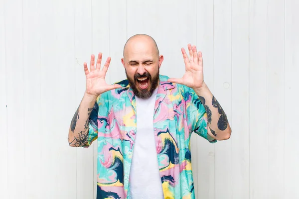 bald man screaming in panic or anger, shocked, terrified or furious, with hands next to head