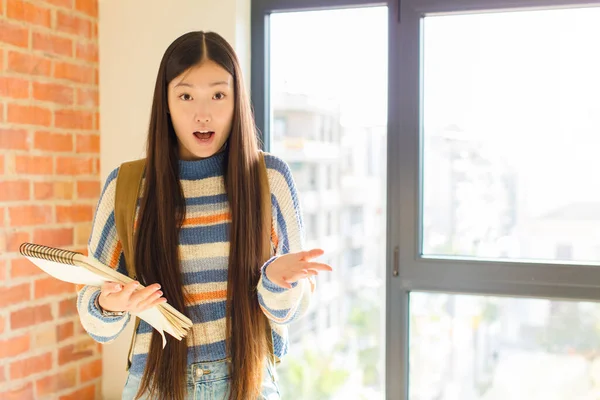 Genç Asyalı kadın şok olmuş ve şaşırmış, endişeli ve paniklemiş, stresli ve dehşete kapılmış bir bakışla