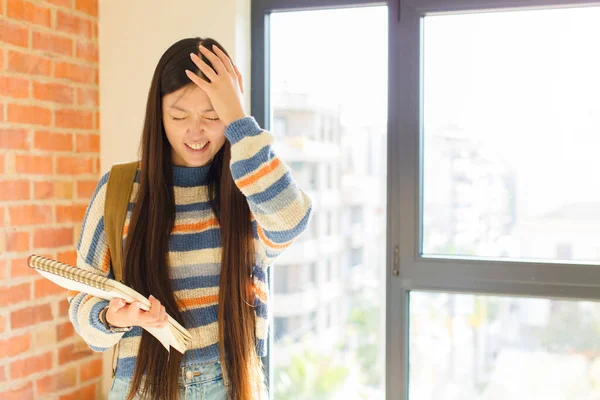 Asyalı genç bir kadın stresli ve hayal kırıklığına uğramış hissediyor. Eli kolu bağlı, yorgun, mutsuz ve migren ağrısı çekiyor.