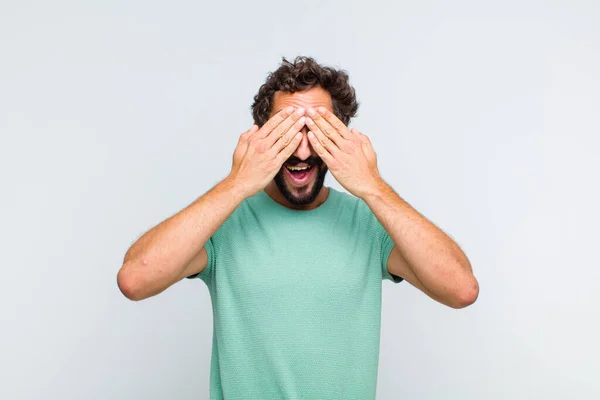 Joven Barbudo Sonriendo Sintiéndose Feliz Cubriendo Los Ojos Con Ambas — Foto de Stock