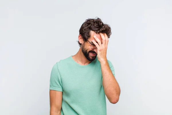 Jonge Man Met Een Baard Die Lacht Zijn Voorhoofd Slaat — Stockfoto