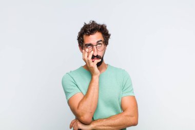 Genç sakallı adam yorgun, sıkıcı ve sıkıcı bir işin ardından sıkılmış, hayal kırıklığına uğramış ve uykulu hissediyor.