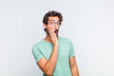 Genç sakallı adam şok olmuş ve ağzı açık halde yüz yüze inanamamaktan şaşkına dönmüş hissediyor.