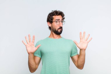 Genç sakallı adam sersemlemiş ve korkmuş hissediyor. Korkutucu bir şeyden korkuyor. Elleri açık ve uzak dur diyor.