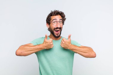 Genç sakallı adam mutlu, pozitif, kendinden emin ve başarılı bir şekilde gülümsüyor.