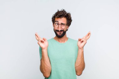 Genç sakallı adam gergin ve umutlu, şans diliyor ve dua ediyor.