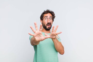 Genç sakallı adam korkmuş hissediyor, korku ve panik içinde geri çekiliyor, kabusa tepki veriyor.