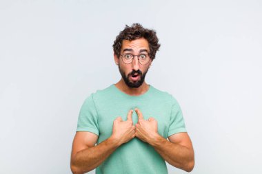 Genç sakallı adam şaşkın ve tuhaf bakışlarıyla kendini işaret ediyor. Seçildiğine şaşırmış ve şaşırmış.