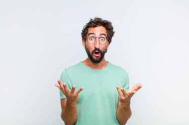 Genç sakallı adam şok olmuş ve şaşırmış, endişeli ve paniklemiş hissediyor, stresli ve dehşete düşmüş bir bakışla