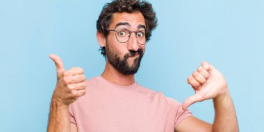 Genç sakallı adam kafası karışmış, bilgisiz ve kararsız hissediyor, iyiyi ve kötüyü farklı seçeneklerle tartıyor.