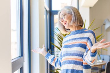 Orta yaşlı bir kadın mutlu, kibirli, gururlu ve kendini beğenmiş görünüyor.