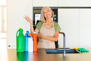 Orta yaşlı kadın gururla ve kendinden emin bir şekilde gülümsüyor, mutlu ve tatmin olmuş hissediyor ve fotokopi alanında bir konsept gösteriyor.