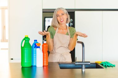 Orta yaşlı bir kadın bilgisiz ve kafası karışık, hangi seçeneği seçeceğinden emin değil, merak ediyor.