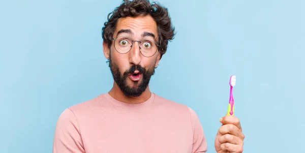 Giovane Uomo Barbuto Guardando Sorpreso Scioccato Con Mascella Caduta Tenendo — Foto Stock