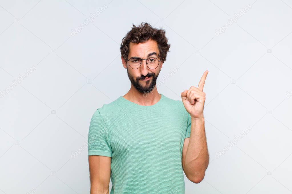 young bearded man feeling like a genius holding finger proudly up in the air after realizing a great idea, saying eureka