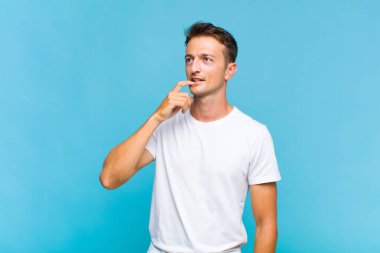 Şaşırmış, gergin, endişeli ya da korkmuş bakışları olan genç yakışıklı bir adam kopya boşluğuna bakıyor.