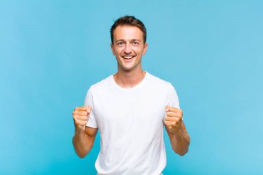 Genç yakışıklı adam şok olmuş, heyecanlı ve mutlu, gülüyor ve başarıyı kutluyor, vay canına diyor.!