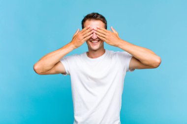 Genç yakışıklı adam gülümsüyor ve mutlu hissediyor, iki eliyle gözlerini kapatıyor ve inanılmaz bir sürpriz bekliyor.