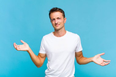 Şaşkın, şaşkın ve stresli görünen genç bir adam. Farklı seçenekler arasında merak ediyor. Belirsiz hissediyor.