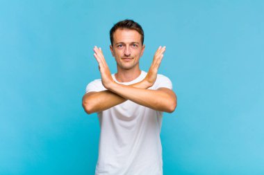 Genç ve yakışıklı adam senin tavırlarından rahatsız ve bıkkın görünüyor, yeter artık! Eller önde çapraz, durmanı söylüyor.