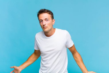 Genç yakışıklı bir adam bilgisiz ve kafası karışık, hiçbir fikri yok, aptal ya da aptal bir bakışla tamamen kafası karışmış.