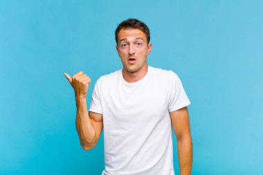 Genç ve yakışıklı adam inançsızlıktan şaşkın şaşkın bakıyor, yan taraftaki objeyi işaret ediyor ve diyor ki vay canına, inanılmaz.