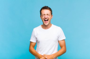 Genç yakışıklı adam agresif bir şekilde bağırıyor, çok kızgın, hayal kırıklığına uğramış, öfkeli ya da sinirli görünüyor, hayır