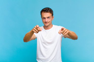 Genç ve yakışıklı bir adam kameraya hem parmaklarını hem de kızgın yüzünü göstererek sana görevini yapmanı söylüyor.