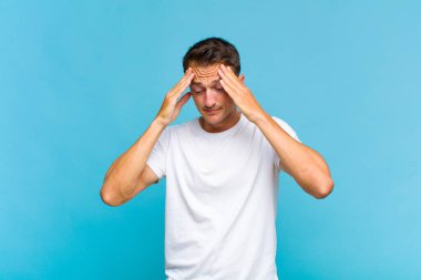 Genç ve yakışıklı bir adam stresli ve hayal kırıklığına uğramış görünüyor. Baskı altında çalışıyor ve sorunları var.