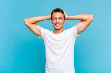 Genç yakışıklı adam mutlu, kaygısız, arkadaş canlısı ve rahat görünüyor. Hayattan ve başarıdan keyif alıyor, olumlu bir tavırla.