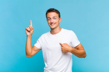 Genç yakışıklı adam gururlu ve şaşırmış, kendine güvenen, kendini bir numara gibi hisseden.