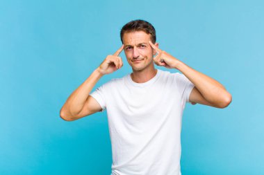 Genç yakışıklı bir adam konsantre olmuş ve bir fikir üzerinde kafa yoruyor, bir meydan okumaya ya da soruna bir çözüm hayal ediyor.