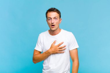 Genç yakışıklı adam şok olmuş ve şaşırmış hissediyor, gülümsüyor, el ele tutuşuyor, o olmaktan mutlu ya da minnettarlık gösteriyor.