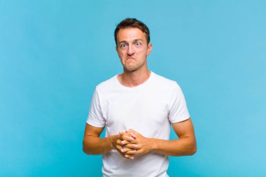 Genç ve yakışıklı adam şapşal ve komik görünüyor. Şaşı bakışlı, şakacı ve şakacı.