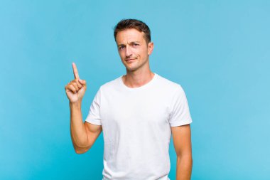 Genç yakışıklı bir adam, harika bir fikri fark ettikten sonra parmağını havaya kaldırıp 