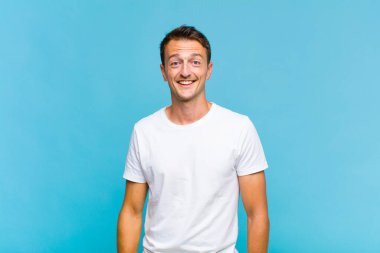 Genç yakışıklı adam mutlu ve hoş bir şekilde şaşırmış görünüyor. Büyülenmiş ve şok olmuş bir ifadeyle heyecanlanıyor.