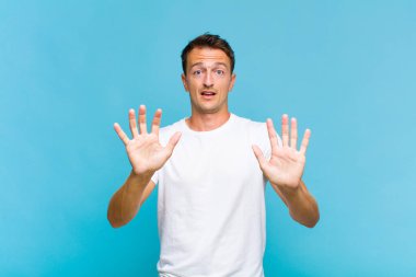 Genç yakışıklı adam sersemlemiş ve korkmuş hissediyor. Korkutucu bir şeyden korkuyor. Elleri açık ve uzak dur diyor.