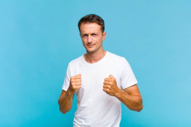 Genç, yakışıklı, kendine güvenen, sinirli, güçlü ve agresif bir adam. Yumrukları boks pozisyonunda dövüşmeye hazır.