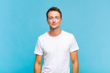 Genç yakışıklı adam dudaklarını birbirine bastırıyor, tatlı, eğlenceli, mutlu, sevimli bir yüz ifadesiyle, öpücük yolluyor.