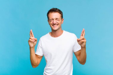 Genç yakışıklı adam gergin ve umutlu, şans diliyor ve dua ediyor.