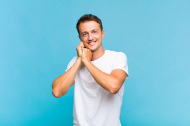 Genç, yakışıklı bir adam aşık ve sevimli görünüyor. Sevimli ve mutlu. Romantik bir şekilde gülümsüyor.