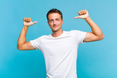 Genç yakışıklı adam gururlu, kibirli ve kendinden emin, tatmin olmuş ve başarılı görünüyor, kendini işaret ediyor.