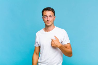 Kafası karışmış, kafası karışmış ve kendine güveni olmayan genç yakışıklı bir adam kendini göstererek kim olduğunu soruyor, ben mi??