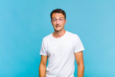 Genç yakışıklı adam kendini cahil, kafası karışmış ve hangi seçeneği seçeceği konusunda kararsız hissediyor, sorunu çözmeye çalışıyor.