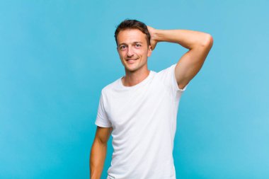 Genç yakışıklı adam neşeyle ve tesadüfen gülümsüyor, olumlu, mutlu ve kendinden emin bir bakışla göğüs göğüse.