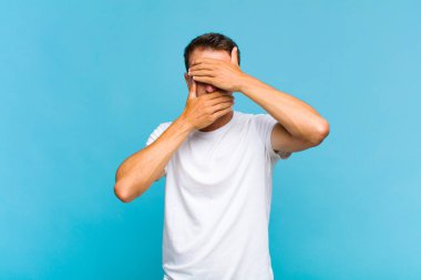 Genç yakışıklı adam kameraya hayır diyen iki eliyle yüzünü kapatıyor! Resimler reddediliyor ya da yasaklanıyor