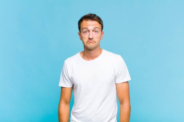 Genç yakışıklı adam üzgün ve stresli, kötü bir sürpriz yüzünden üzgün, olumsuz, endişeli bir bakışla