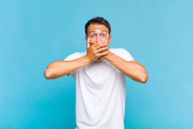 Şok olmuş, şaşırmış bir ifadeyle ağzı kapalı genç yakışıklı bir adam sır saklıyor ya da 